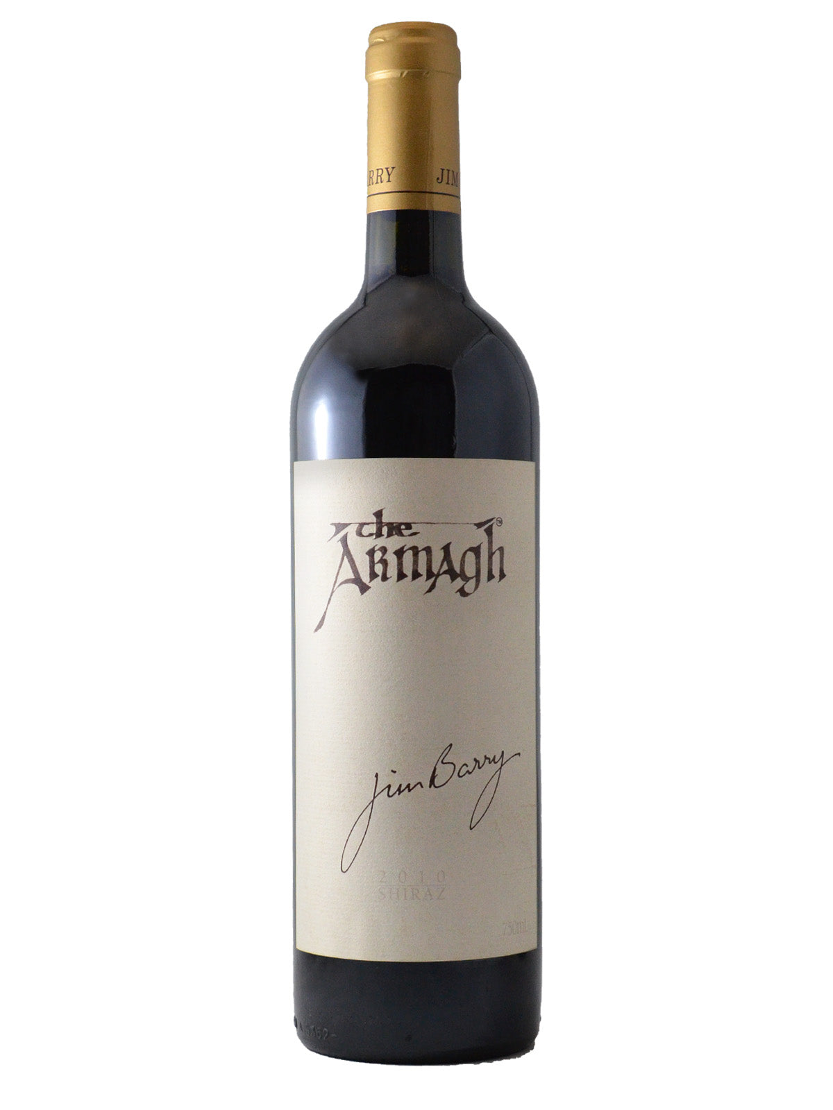 Bottle of Jim Barry The Armagh 2010 wine with a tan label visible showing the name of the wine and a facsimile of Jim Barry's personal signature. Gold enclosure (over a cork). All set against white background.
