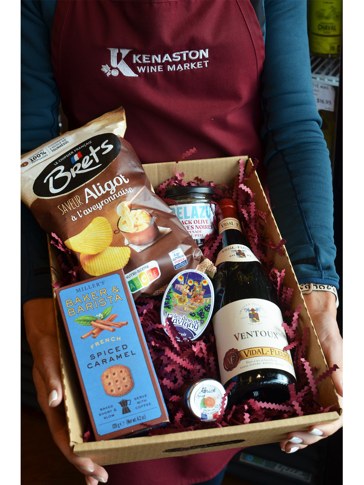 Person holding a gift box with food and wine from Kenaston Wine Market