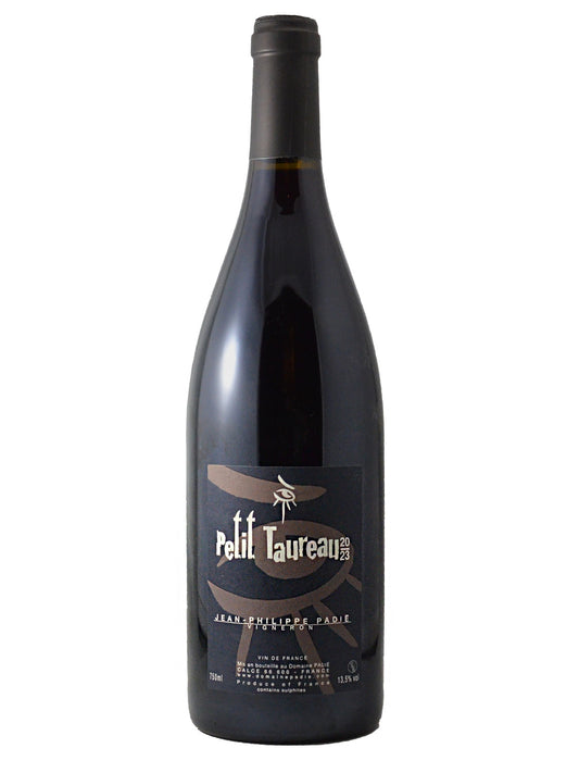 A bottle of Petit Taureau Jean Proulx Red Wine with a brown/grey enclosure and a black/brown-grey/white text and 'eye' artwork label, set against a plain white background.
