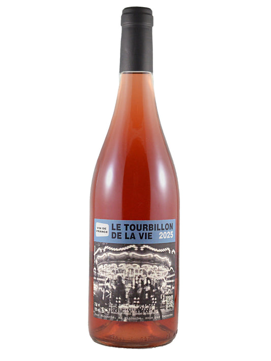 A bottle of rosé wine with clear glass showing the pink wine within nd a dark gunmetal enclosure and a black-and-blue label reading 'LE TOURBILLON DE LA VIE 2025' & 'VIN DE FRANCE' above a vintage black and white photograph of a carousel, shown on a plain white background.