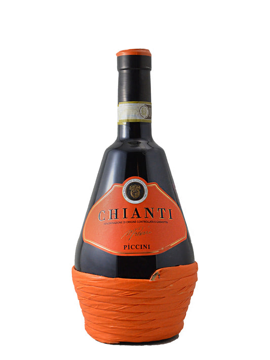 A 'fiasco' style bottle of Chianti Riserva Piccini wine with a distinctive bright orange basket-paper-wrapped base, set against a plain white background.