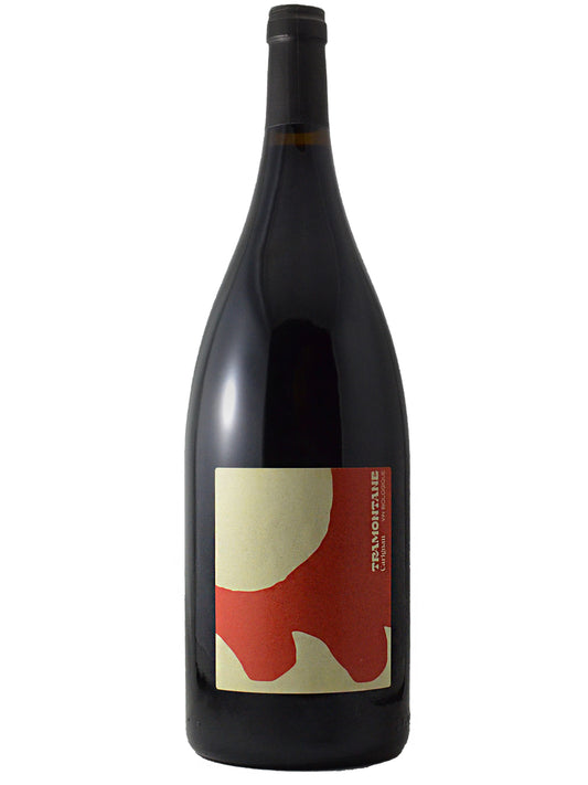 A dark glass wine bottle in a 1.5L magnum-size with a black capsule and a minimalist label featuring abstract organic shapes in beige and red, set against a plain white background.
